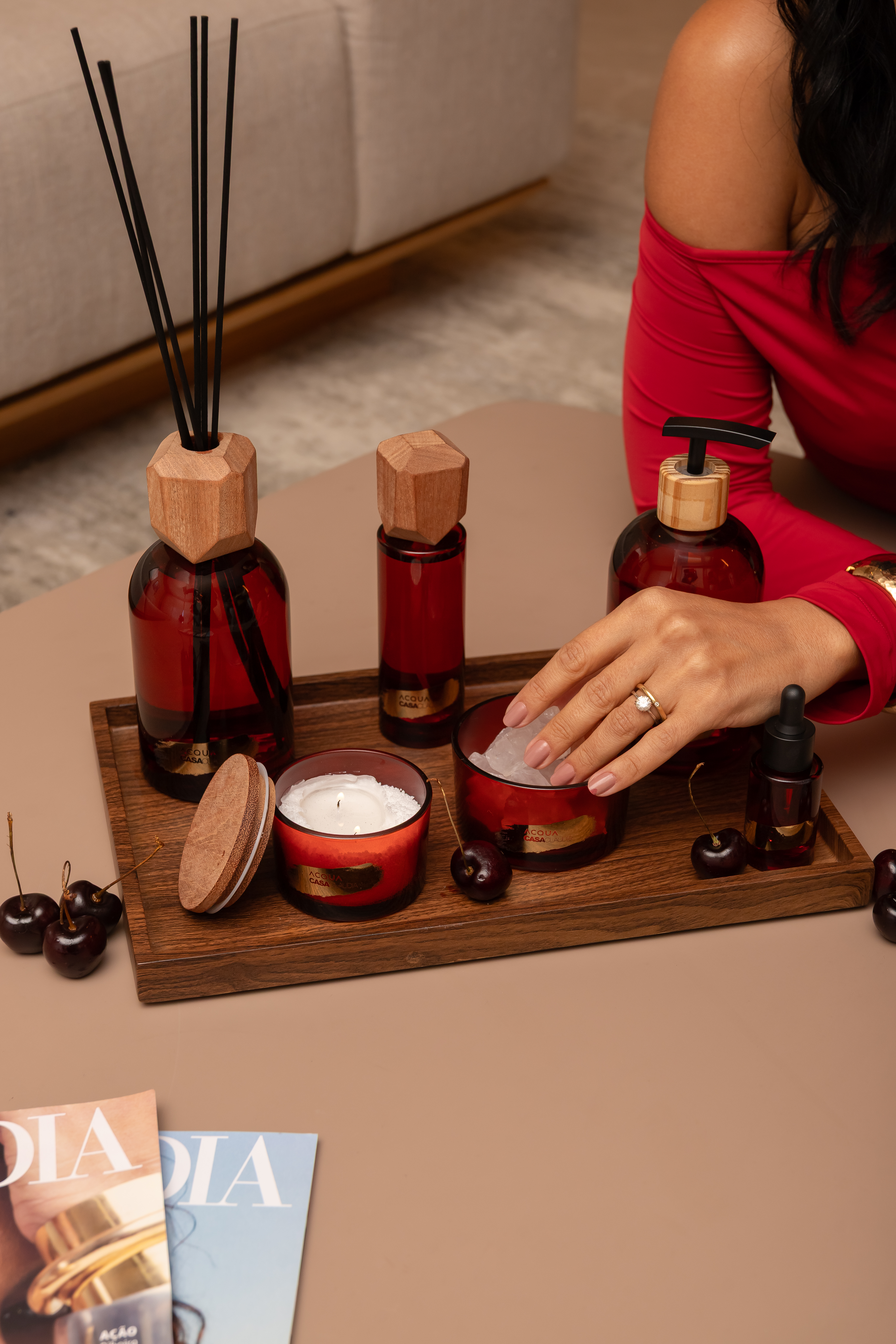 M&atilde;o de mulher mexendo em cristal arom&aacute;tico com embalagem vermelha