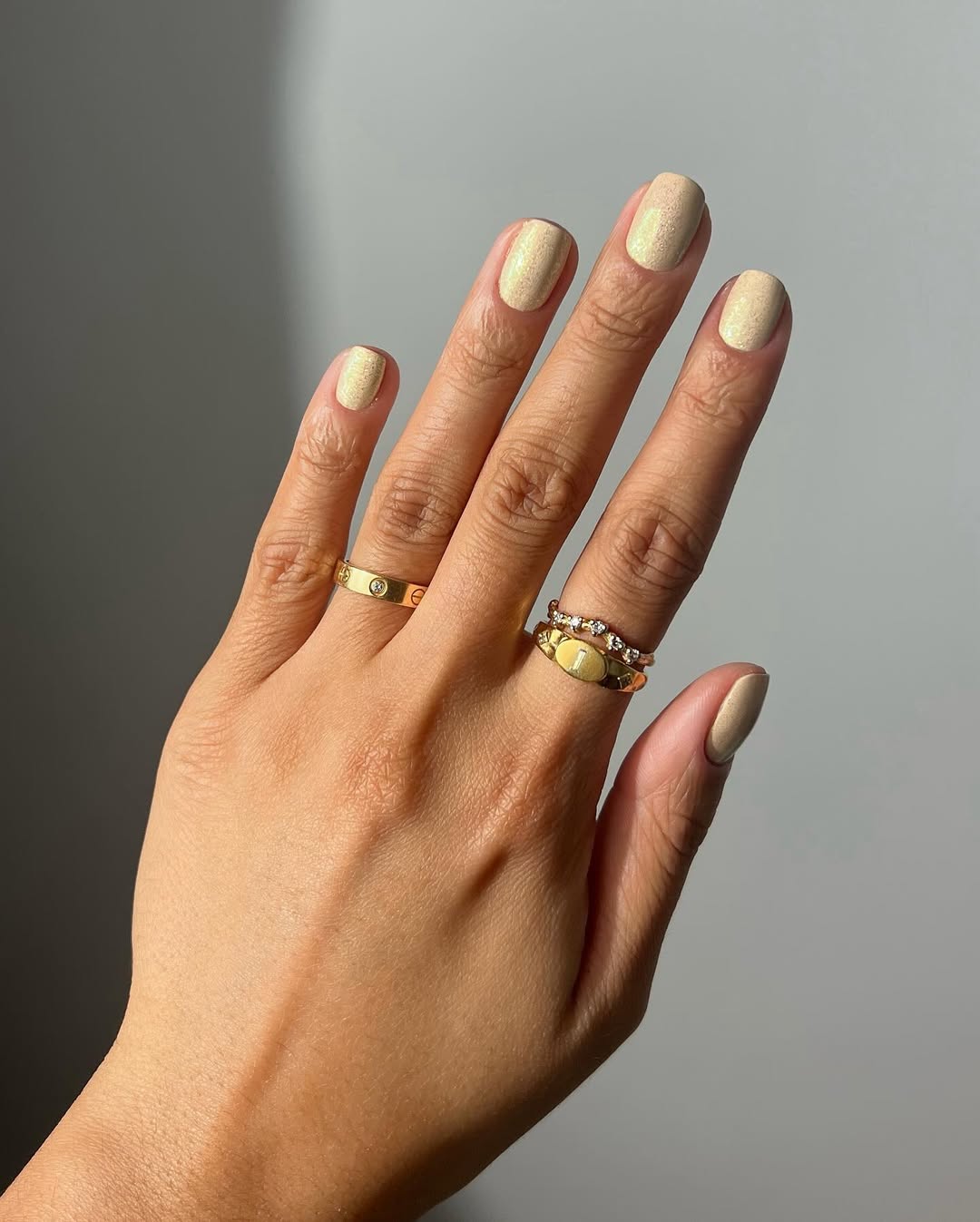 Foto de uma m&atilde;o com as unhas coloridas de amarelo can&aacute;rio