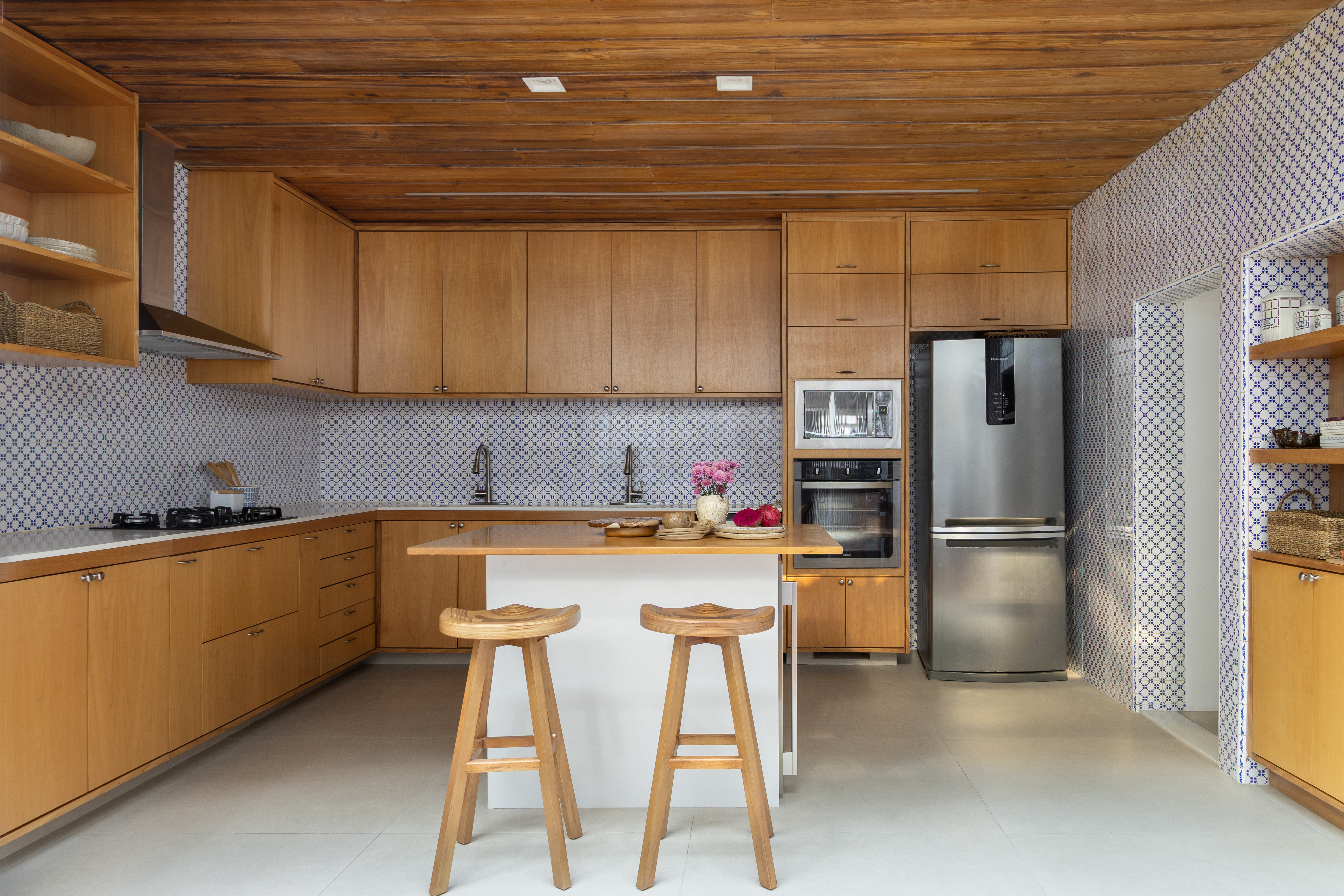 Cozinha com predomin&acirc;ncia de elementos em madeira e azulejo azul