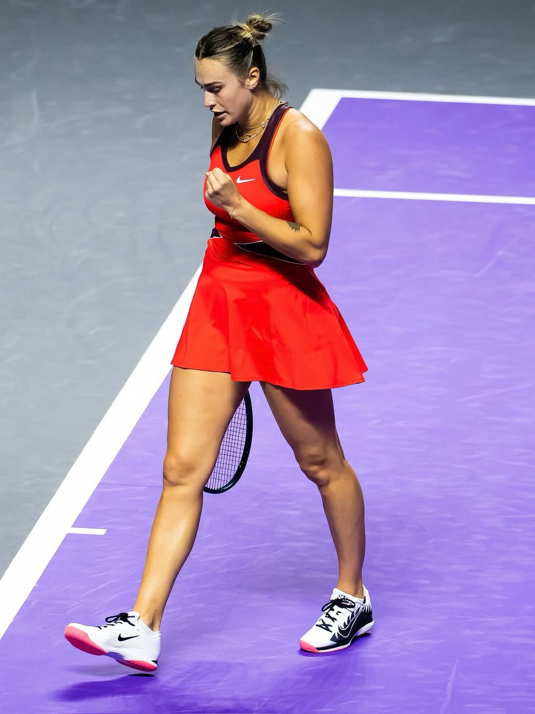 Foto de uma mulher loira usando um look composto por vestido vermelho e t&ecirc;nis para praticar o esporte t&ecirc;nis