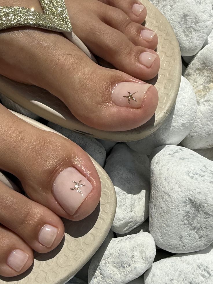 Nail art nude com estrela dourada para p&eacute;s