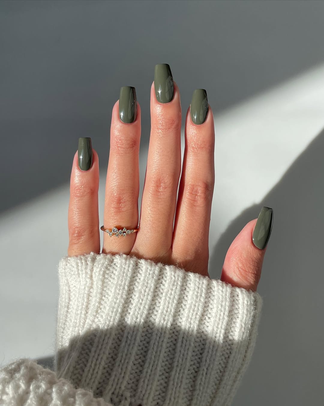 Foto de uma m&atilde;o com as unhas coloridas de verde musgo