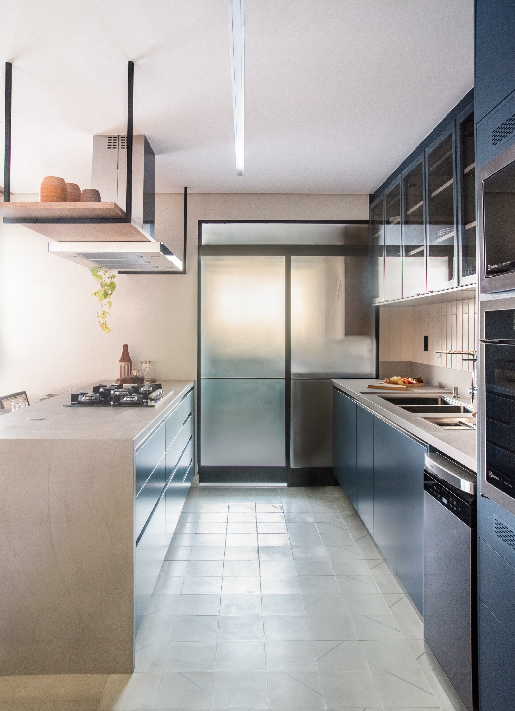 Cozinha americana com divis&oacute;ria de vidro boreal para a lavanderia