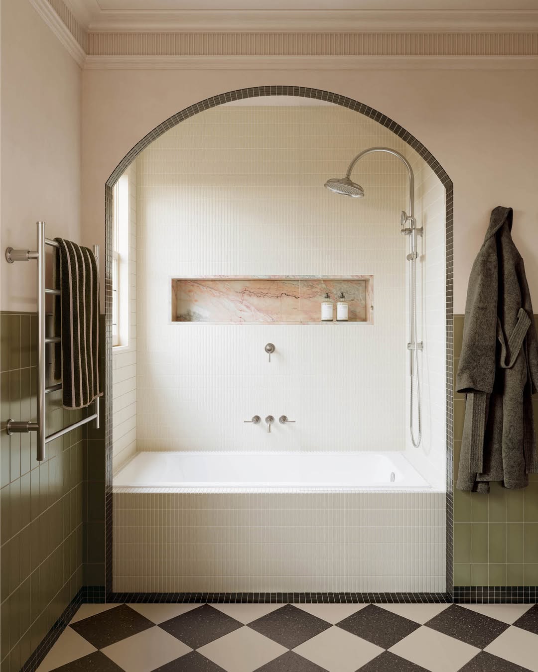 Banhweiro com grande arco no teto e piso quadriculado
