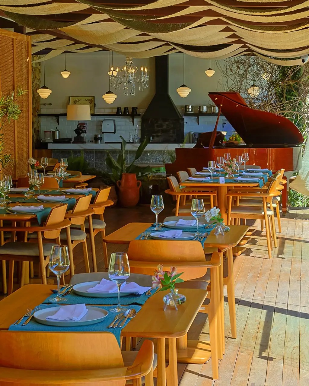 Restaurante iluminado com mesas de duas pessoas distribu&iacute;das no sal&atilde;o
