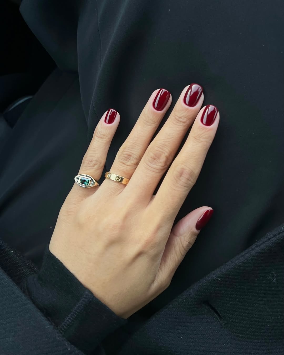 Foto de uma m&atilde;o com unhas coloridas de vinho