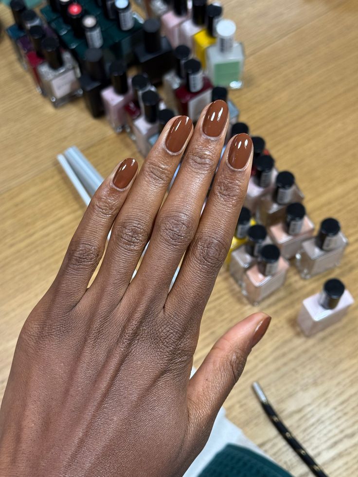 Esmalte marrom chocolate em unhas amendoadas valorizando a pele negra