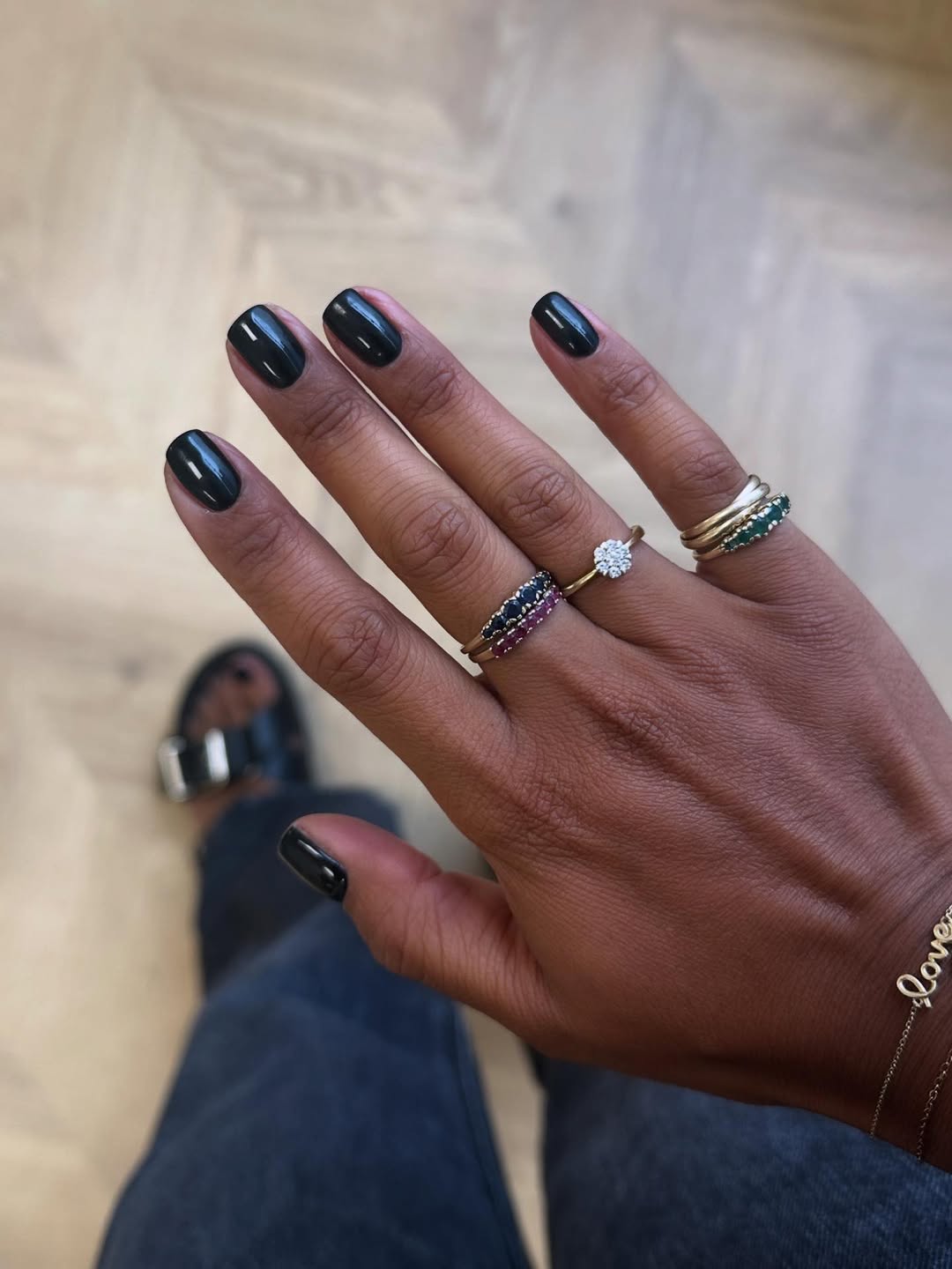 Esmalte preto brilhante em unhas curtas valorizando a pele negra