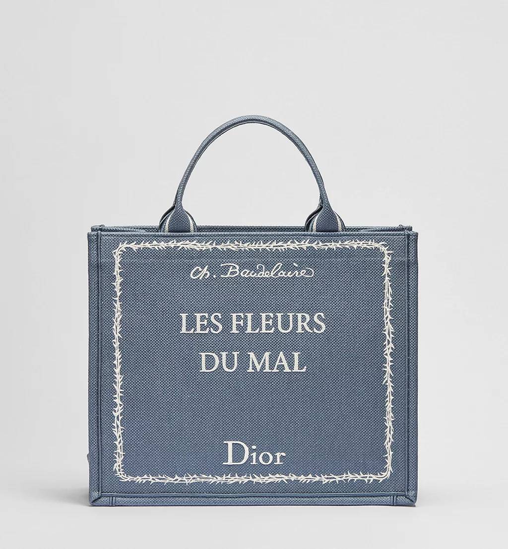 Dior Book Tote azul com bordado &ldquo;Les Fleurs du Mal&rdquo; de Charles Baudelaire, bolsa de luxo inspirada em cl&aacute;ssico da poesia francesa, parte da cole&ccedil;&atilde;o liter&aacute;ria da Dior assinada por Jonathan Anderson.