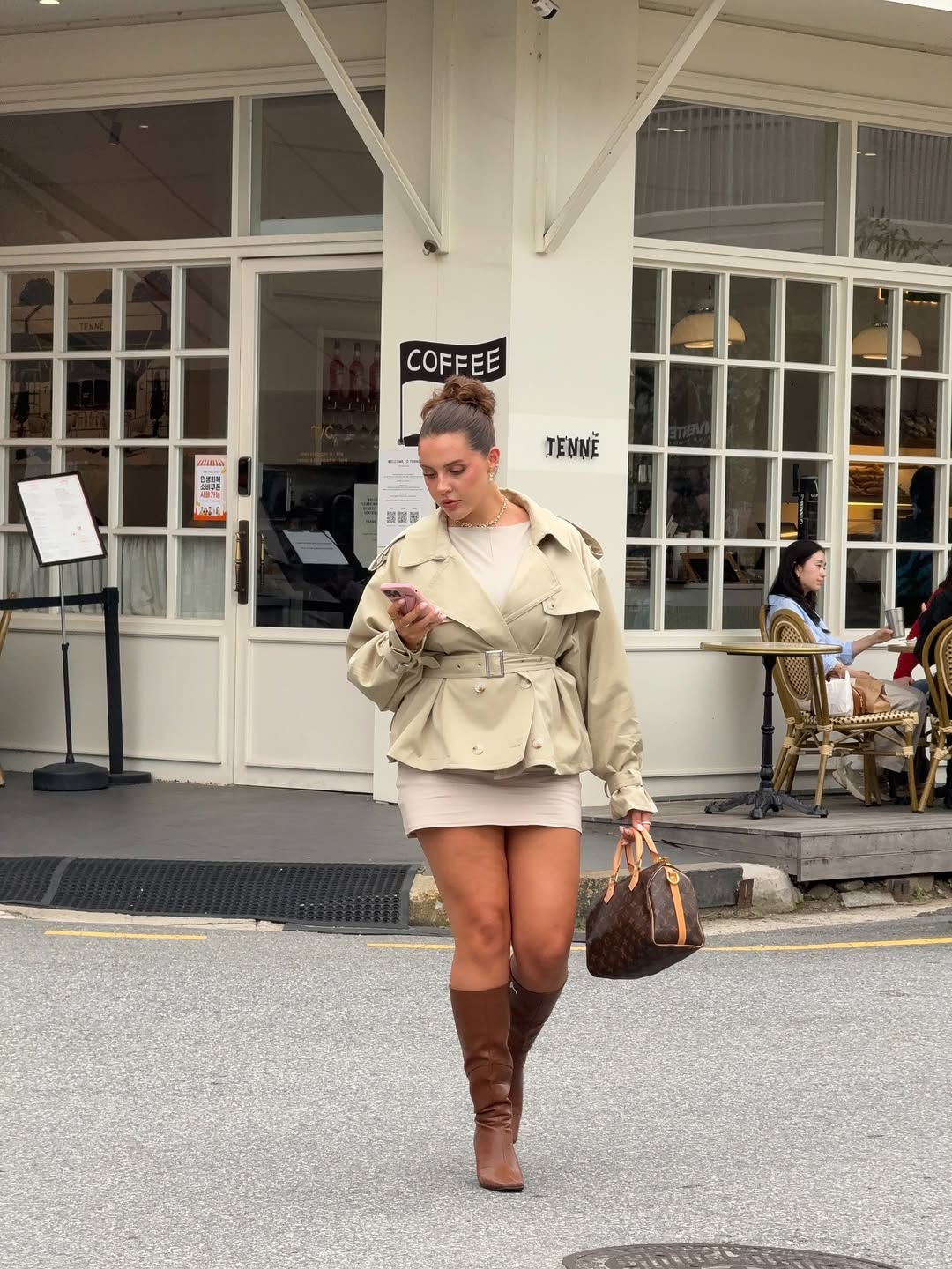 Trench curto com vestido e bota de cano alto marrom cria silhueta mais longa e elegante