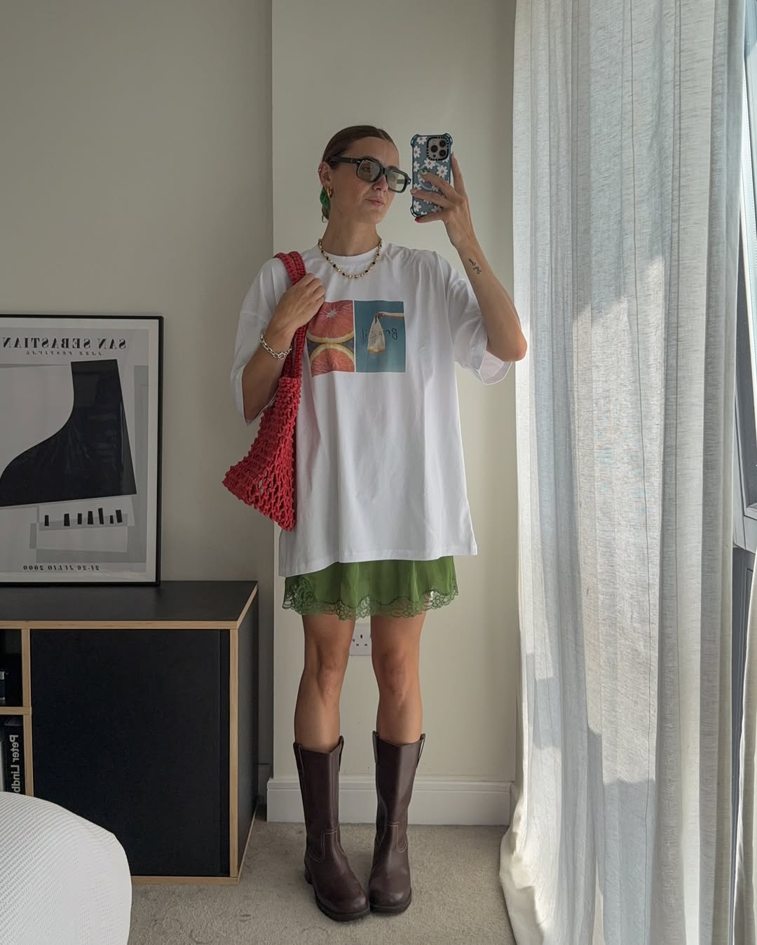 T-shirt oversized com saia leve e bota de cano alto marrom cria look confort&aacute;vel que alonga