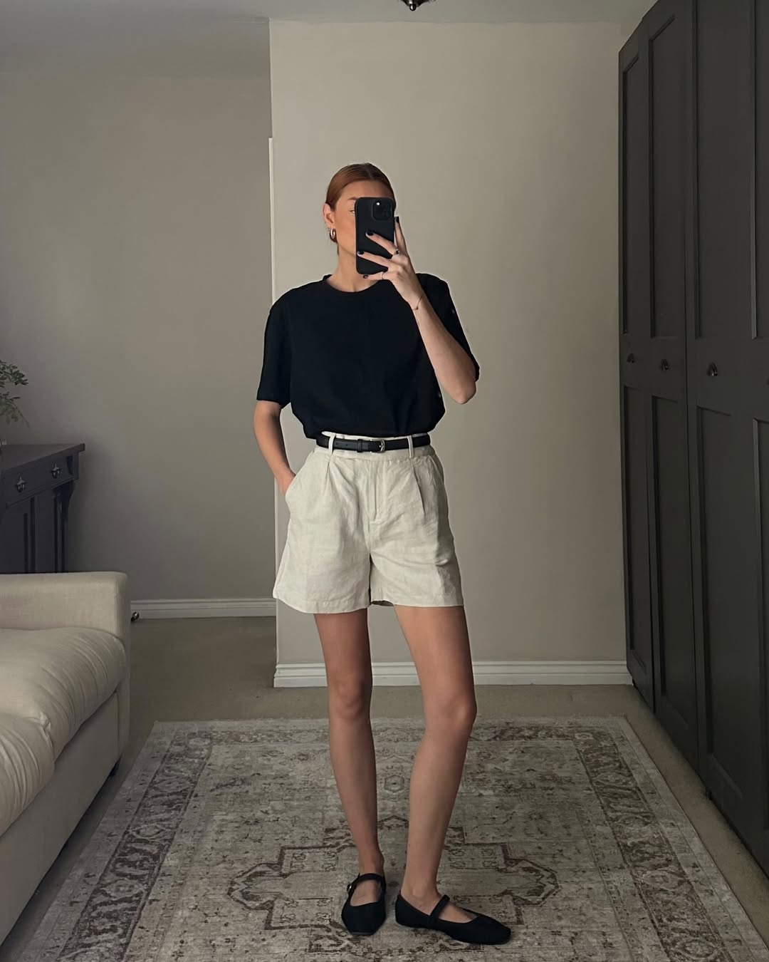 Look cl&aacute;ssico com shorts de linho bege e camiseta preta para o trabalho