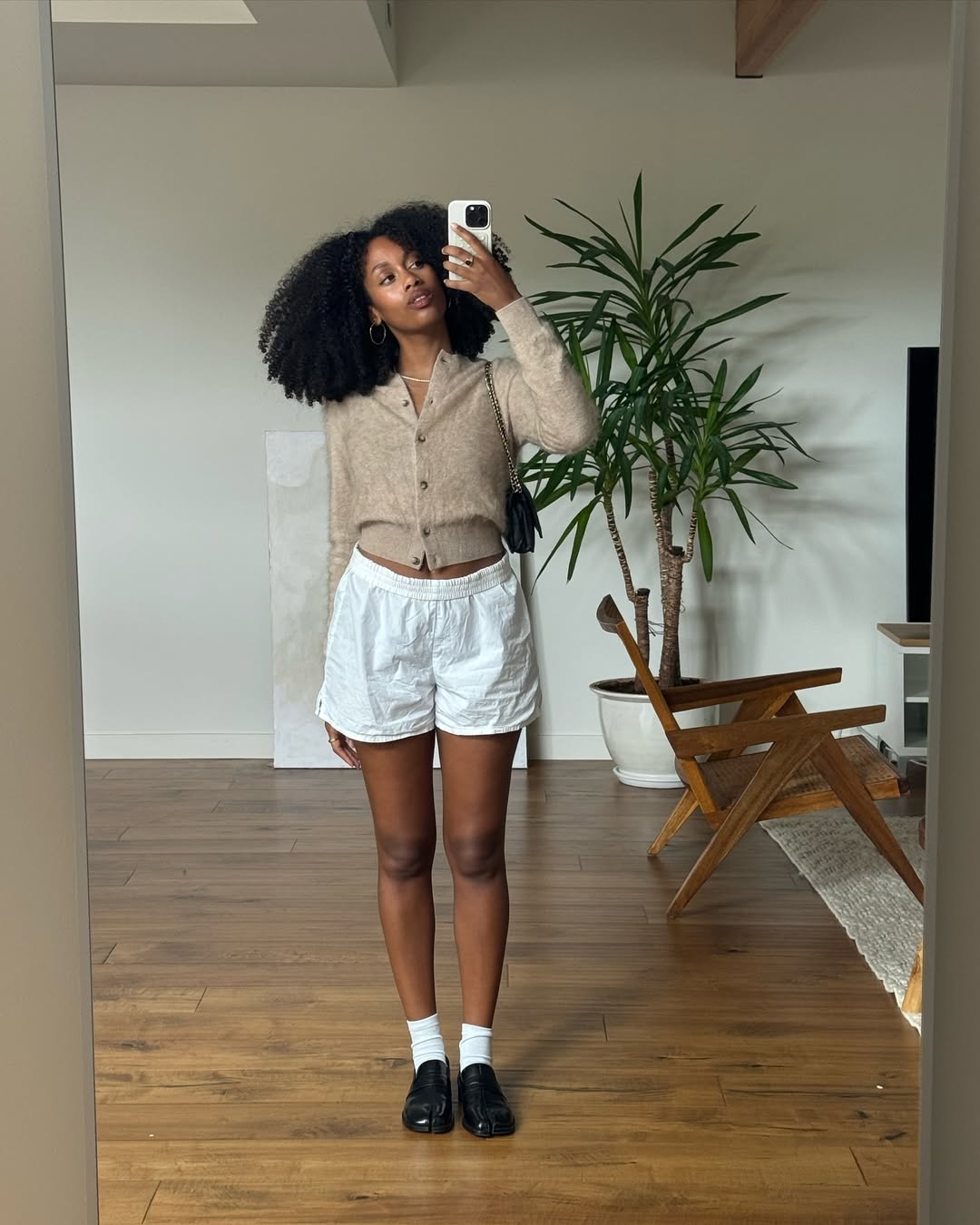 Shorts de linho claro com camisa preta para um look profissional moderno