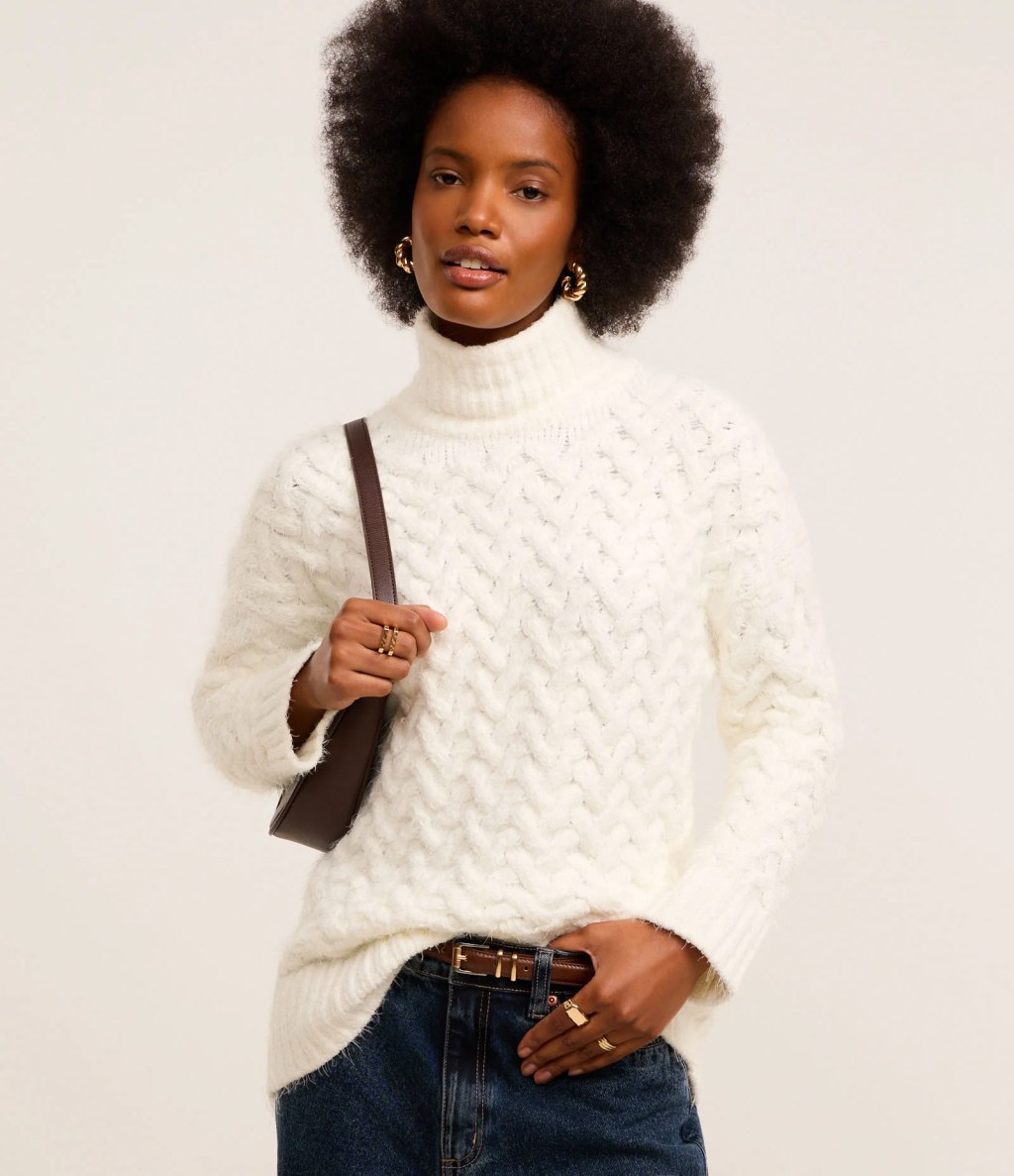 Foto de uma mulher negra usando uma blusa branca de tric&ocirc;