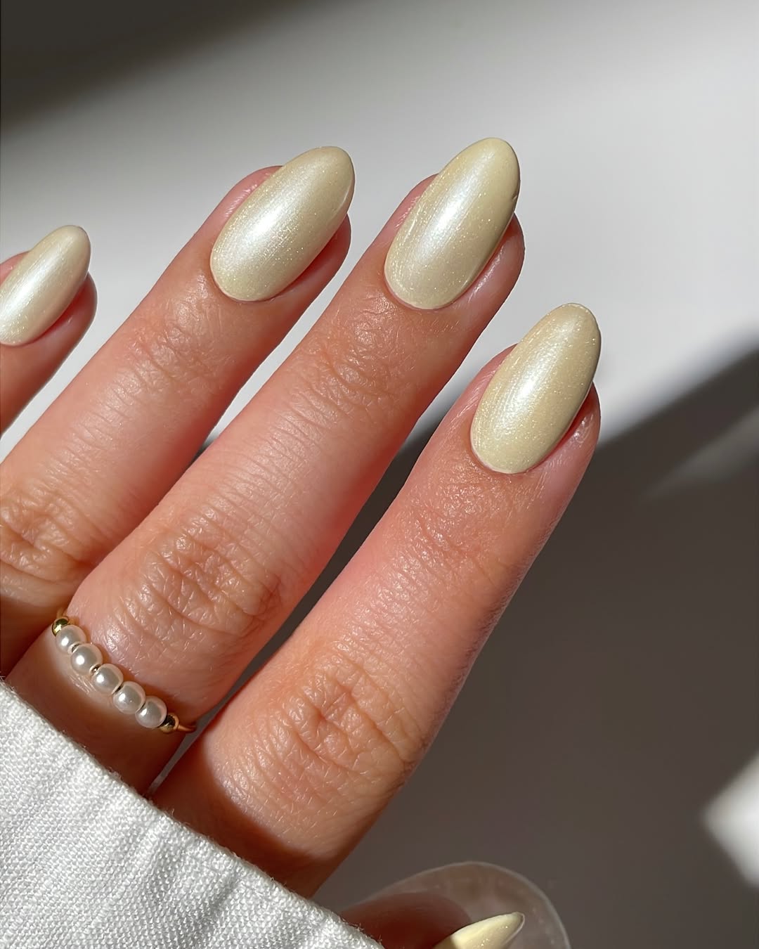 Close em m&atilde;o feminina usando unhas em tom de amarelo cromado