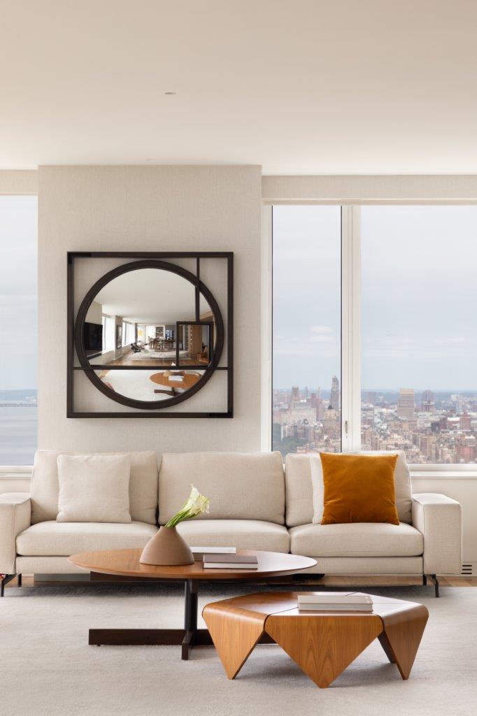 Apartamento em NY com janelas para a cidade, paredes brancas e espelho geom&eacute;trico preto