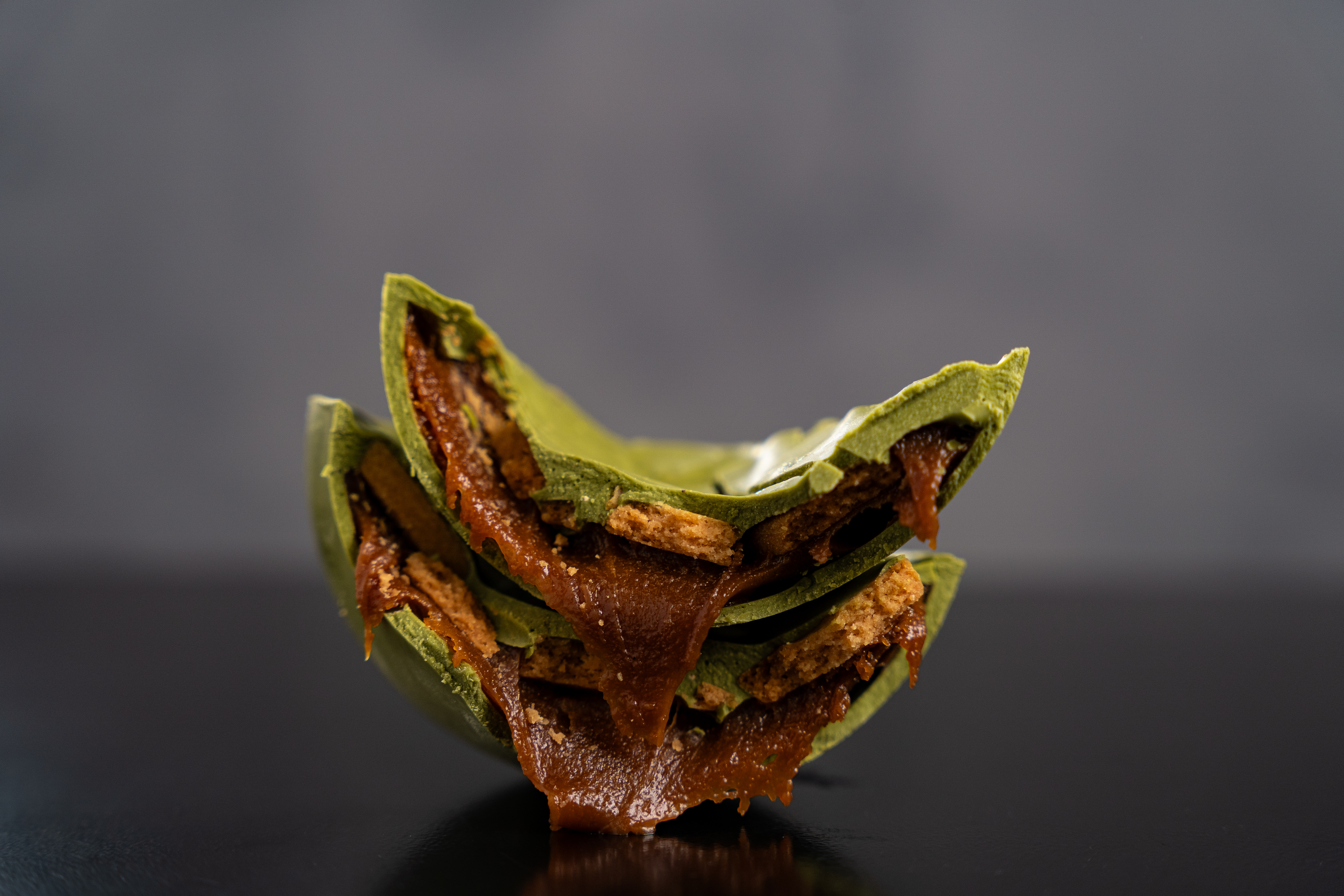 Ovo de p&aacute;scoa verde recheado com chocolate e caramelo cortado ao meio