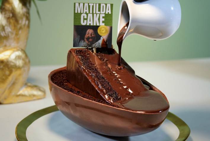 Ovo de p&aacute;scoa com muito recheio de bolo de chocolate quadrado ao meio com calda por cima