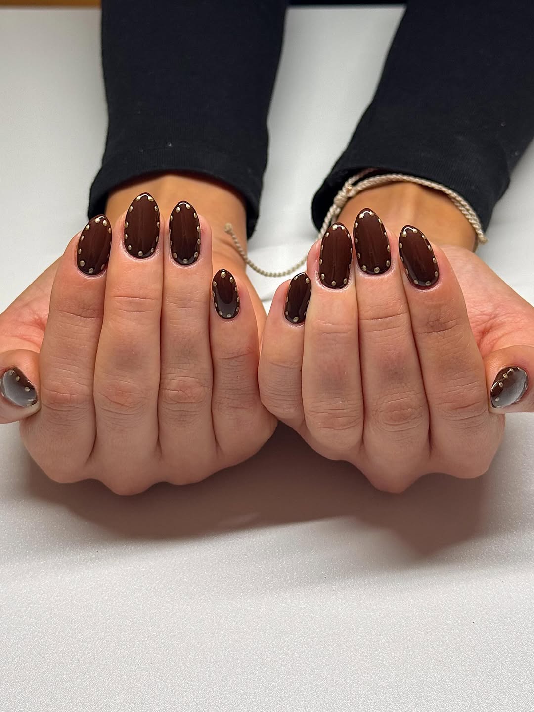 Unhas marrom escuro com aplica&ccedil;&otilde;es met&aacute;licas criam visual elegante e moderno