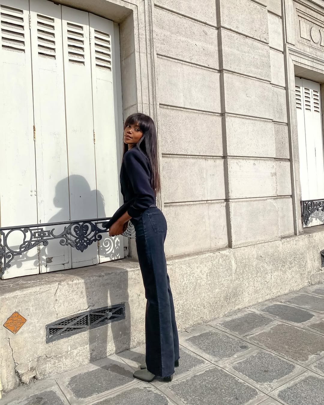 Foto de uma mulher negra usando um look all jeans, com a cal&ccedil;a sendo boot cut