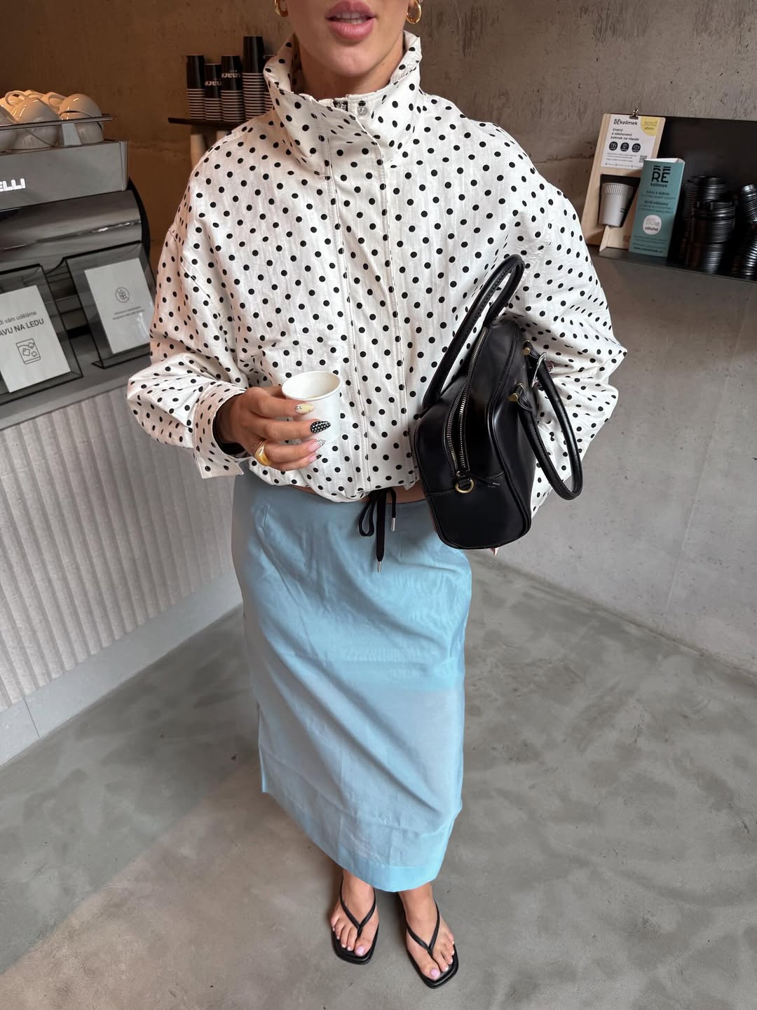 Saia azul Bridgerton combinada com jaqueta branca de po&aacute; em look casual chic