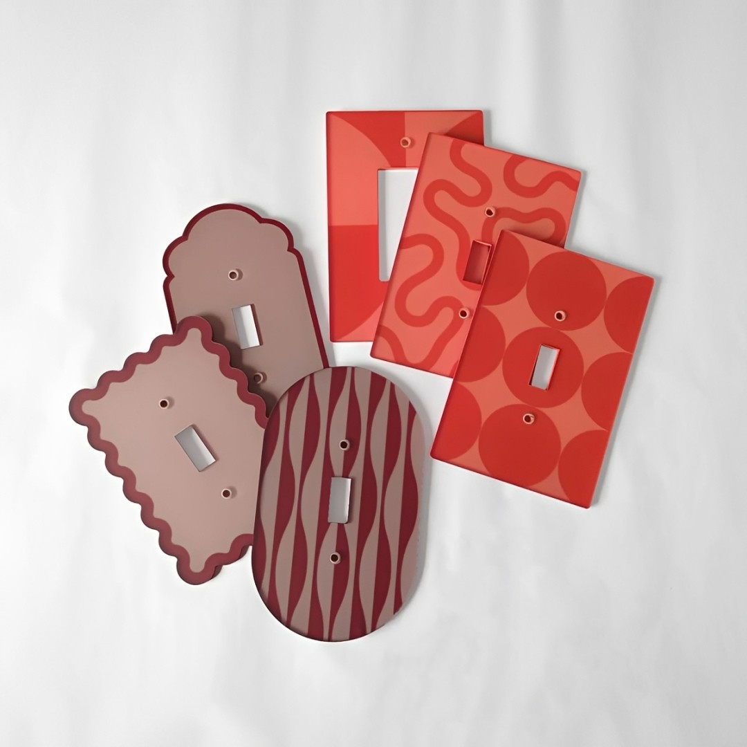 Molduras de interruptor em acr&iacute;lico diversasem tons de vermelho e rosa