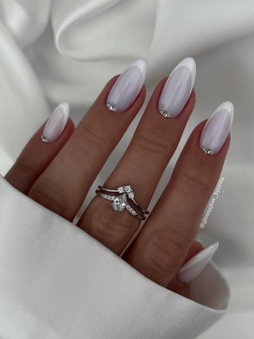 Unhas francesinhas brancas decoradas com pequenas pedrarias