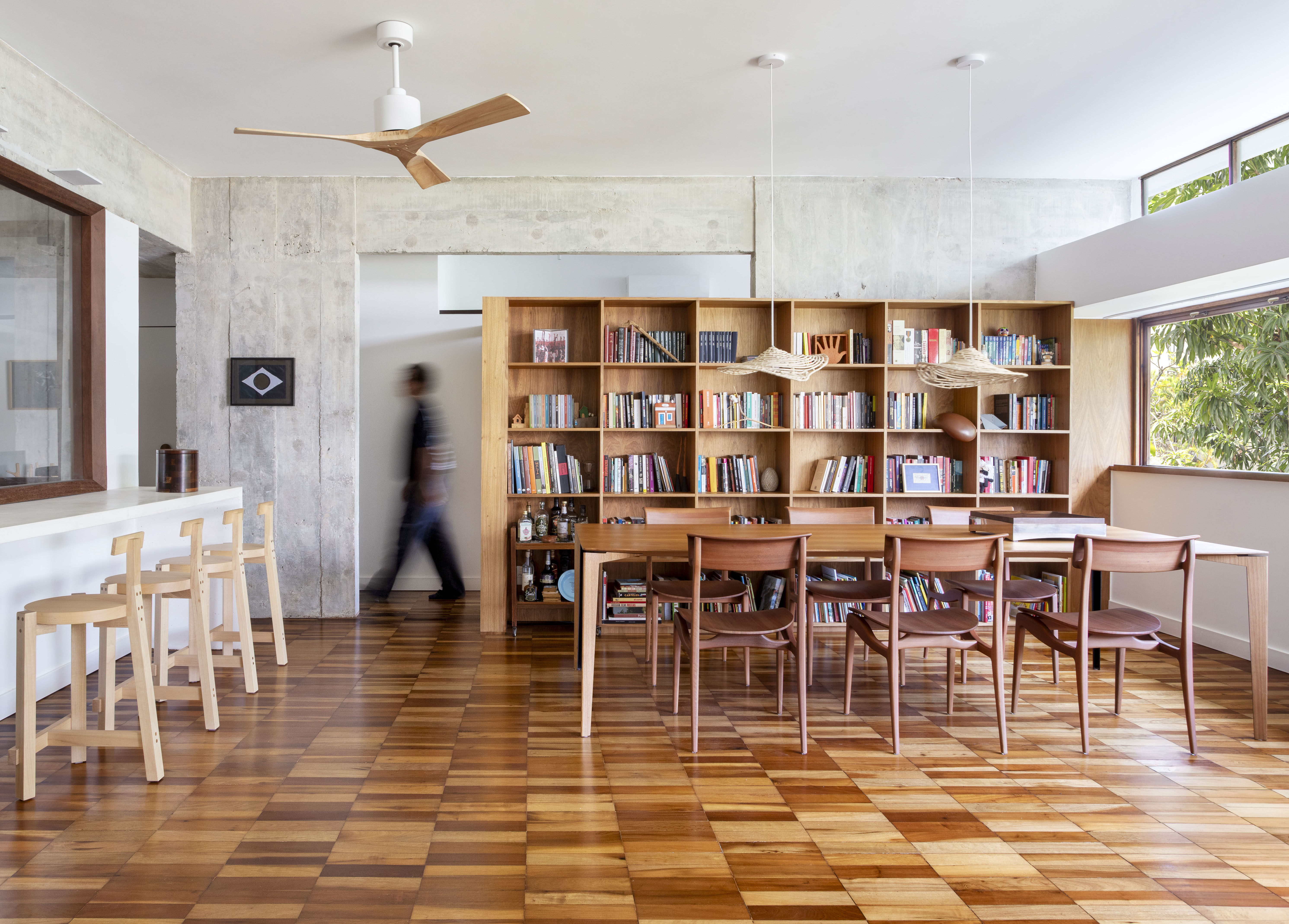 Sala de estar com piso de taco e parede de cimento queimado