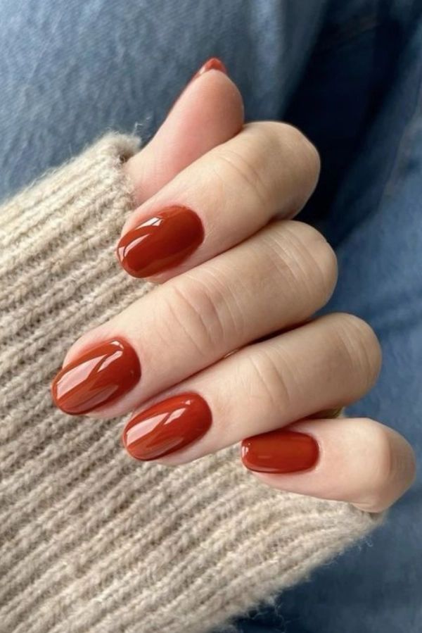 M&atilde;os femininas mostrando unhas marrom alarajadas