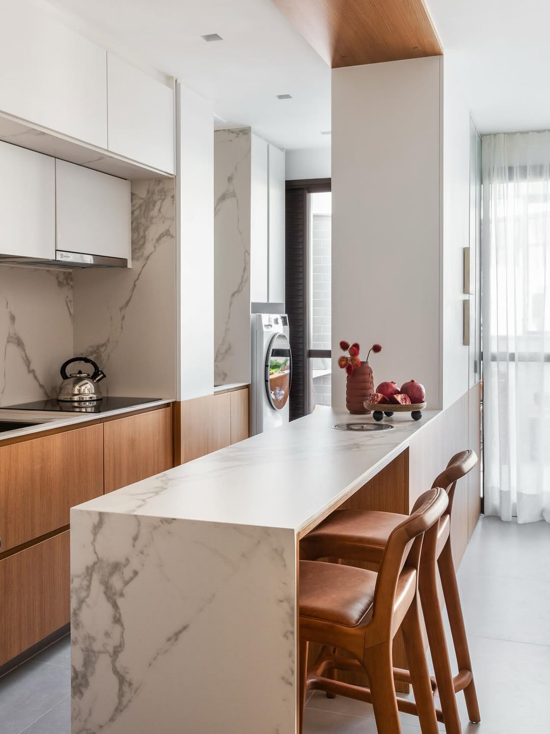 Cozinha pequena com bancada de m&aacute;rmore e bancos de madeira