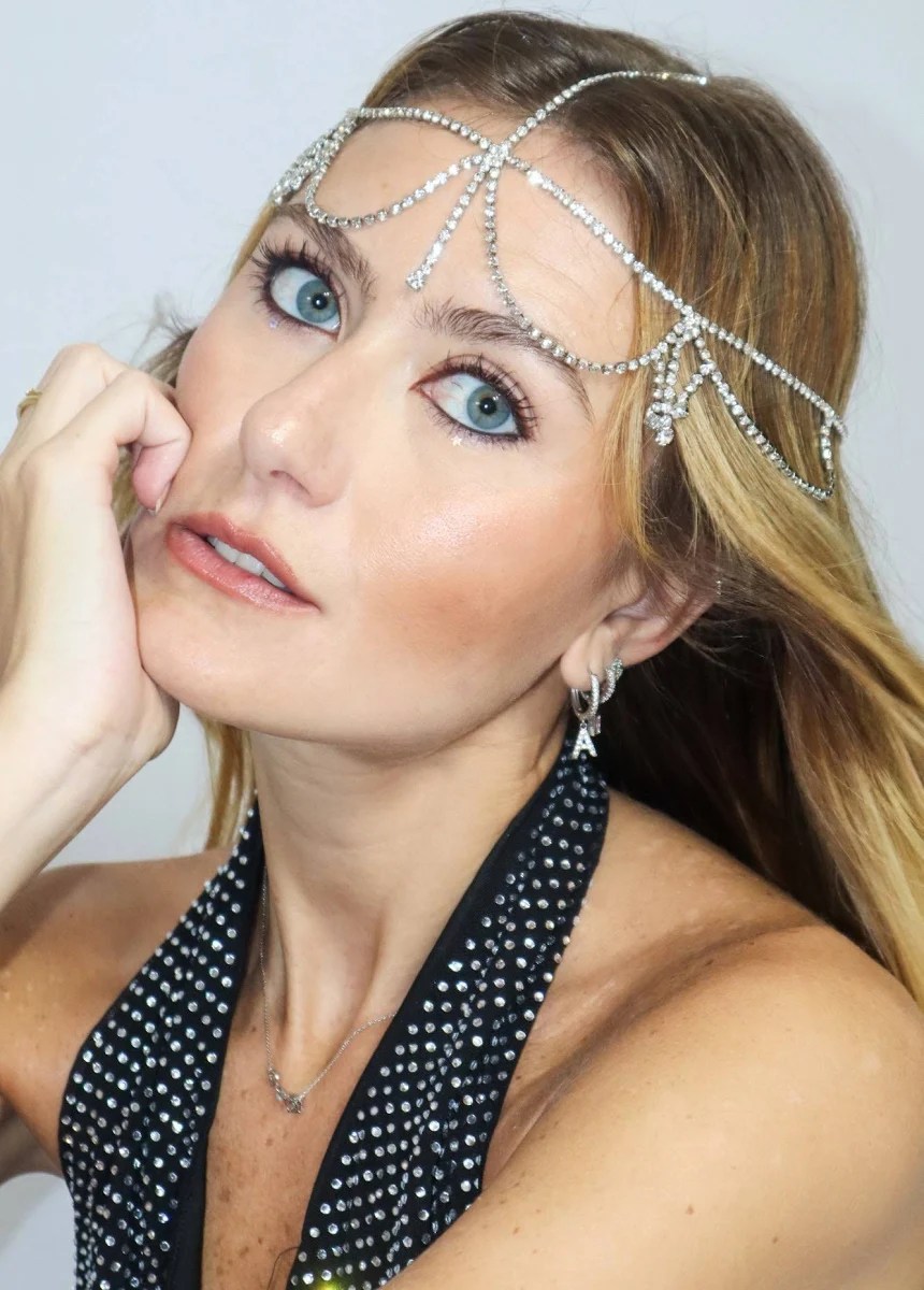 Foto de uma mulher loira usando um headpiece com pedrarias