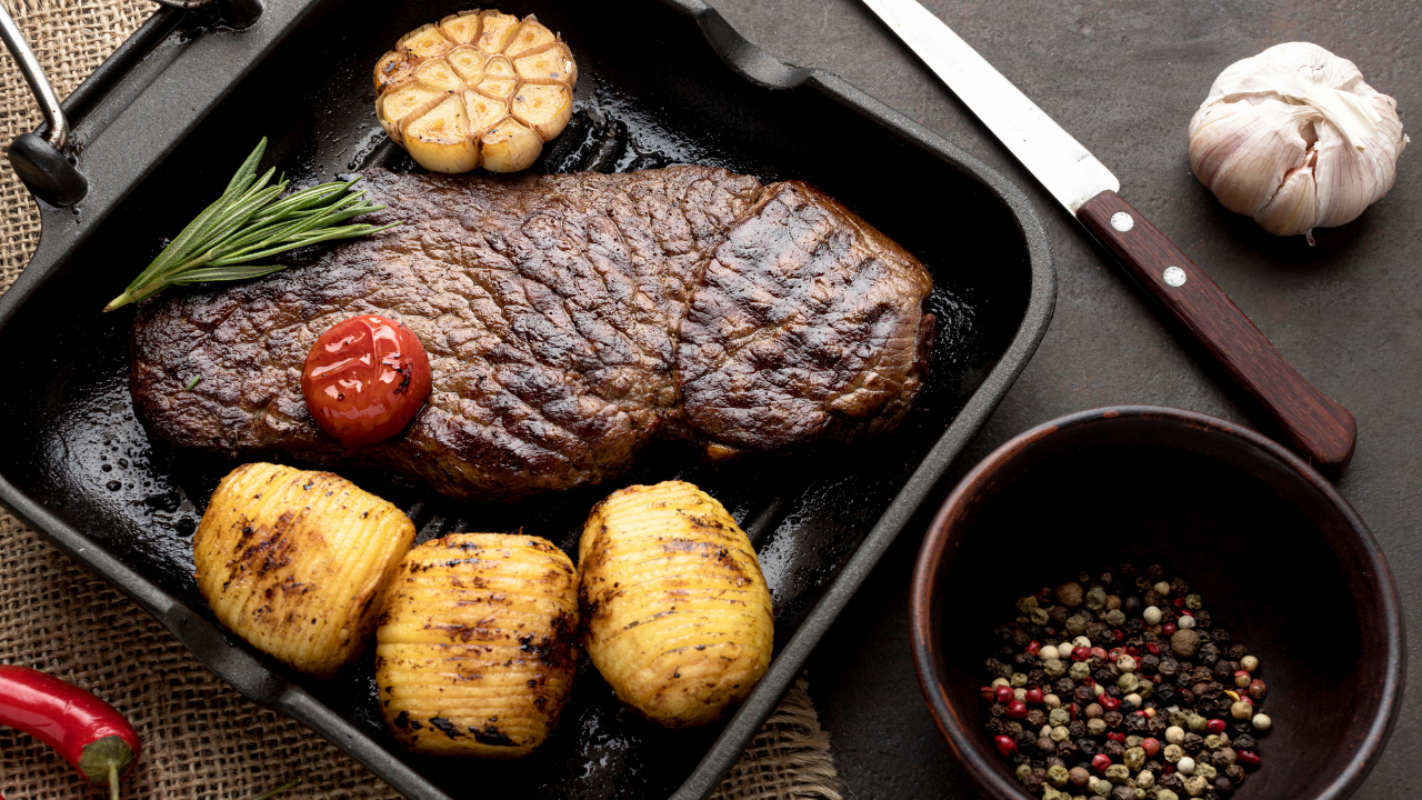 Carne servida em tábua de ferro preta com batatas