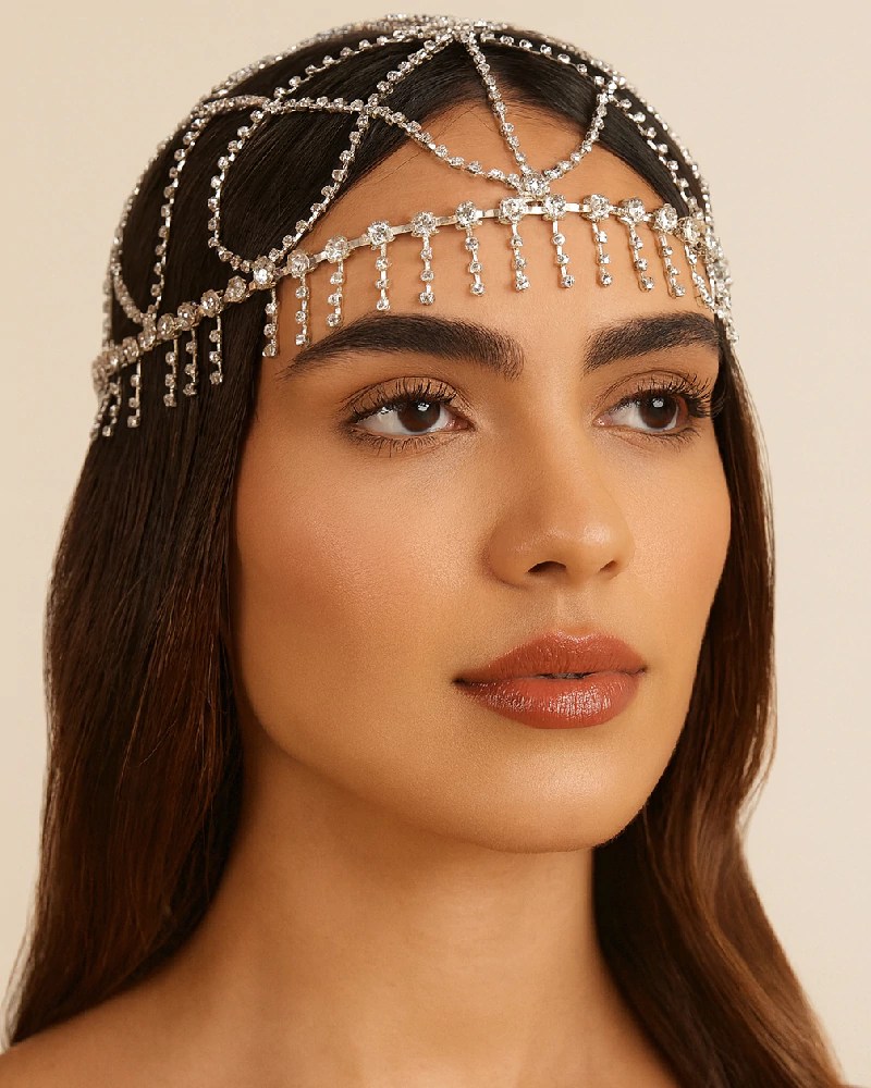 Foto de uma mulher morena usando um headpiece com pedrarias