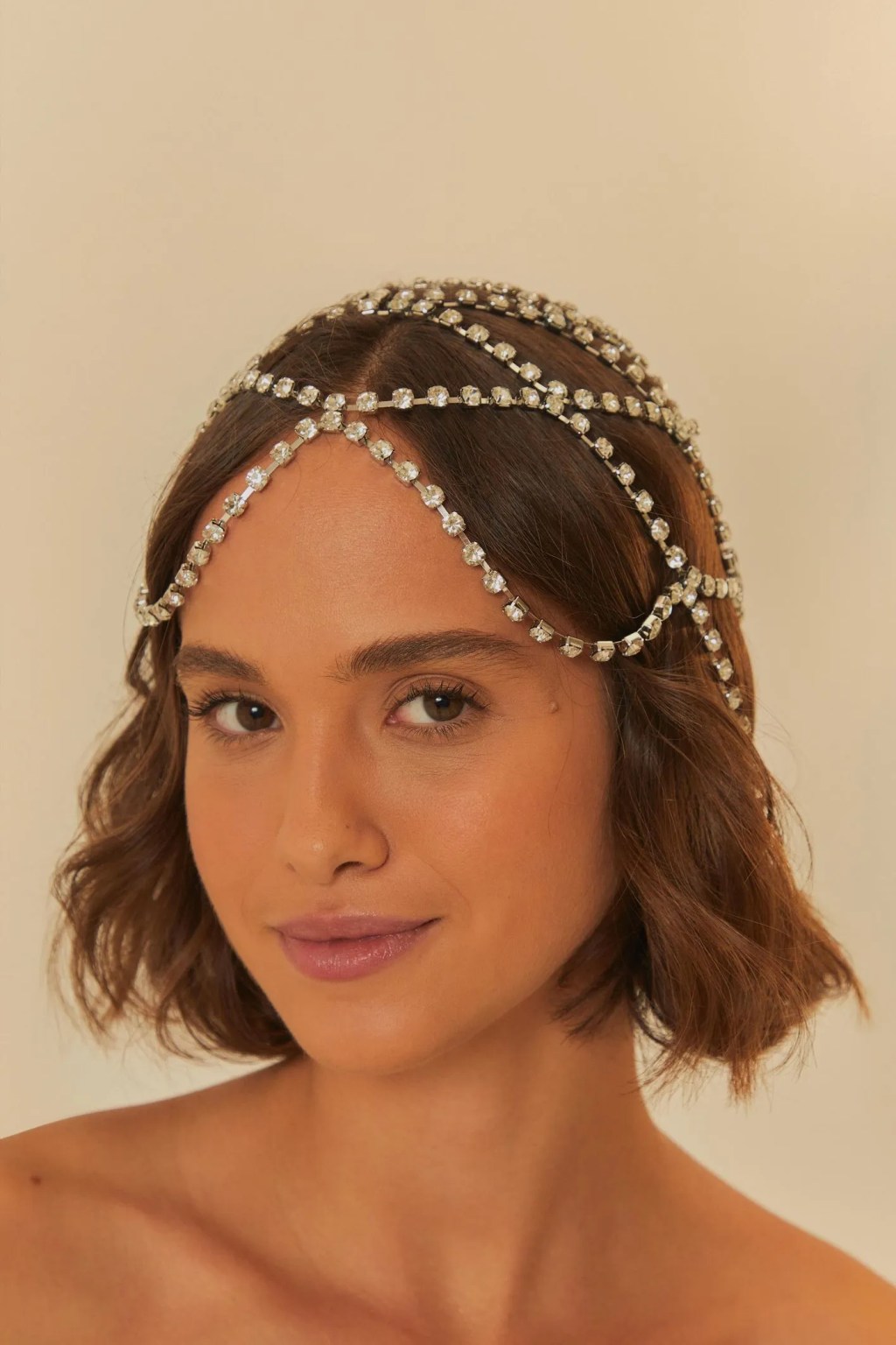 Foto de uma mulher morena usando um headpiece com pedrarias