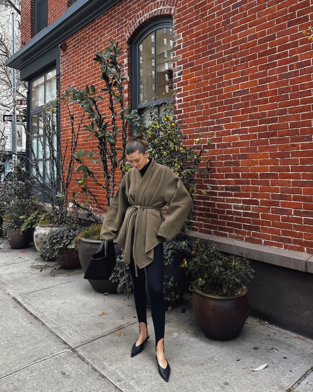 Foto de uma mulher loira usando um look composto por um blazer verde musgo, cal&ccedil;a fus&ocirc; e sapatilha