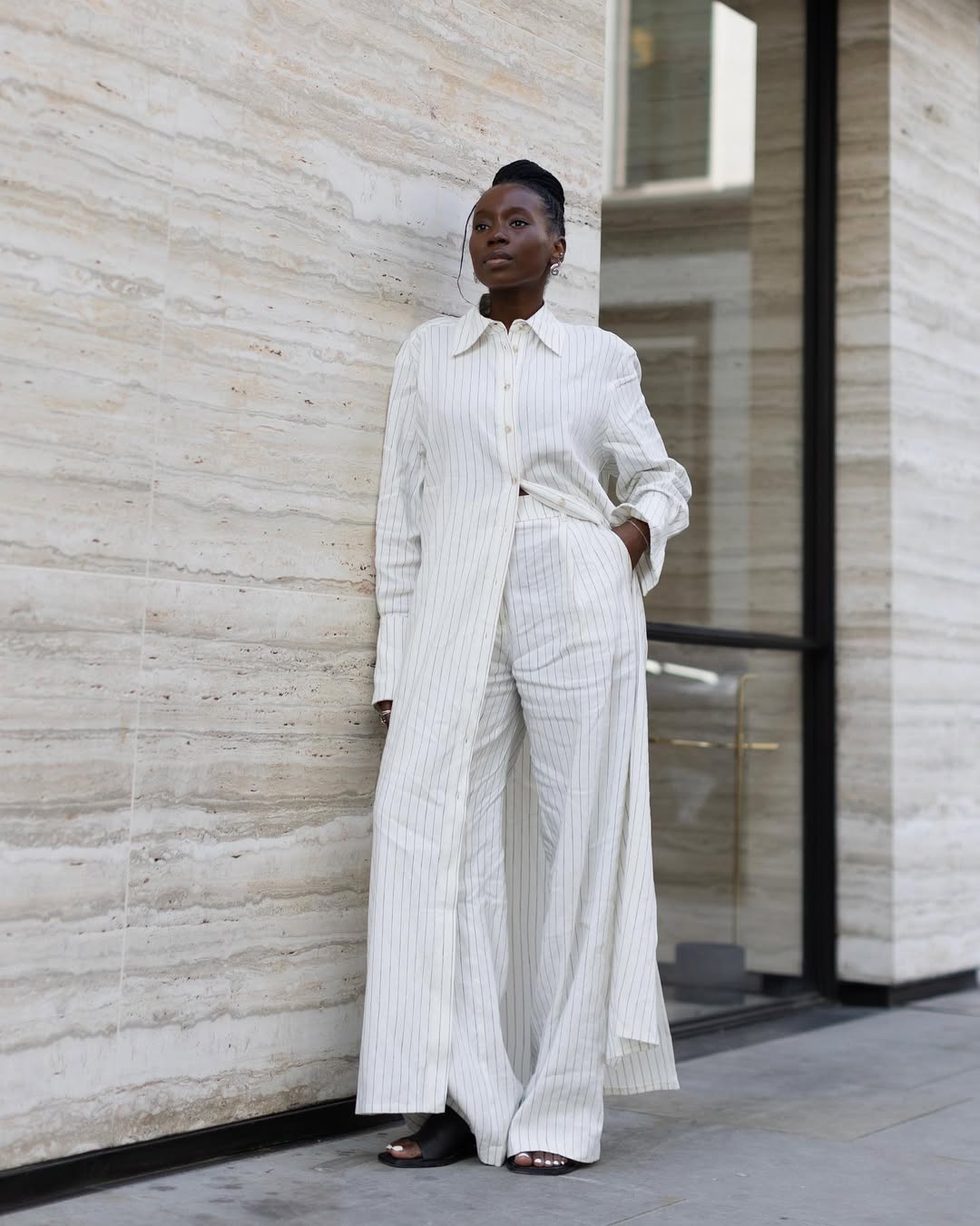 Foto de uma mulher negra usando um look composto por camisa, cal&ccedil;a e rasteirinha social