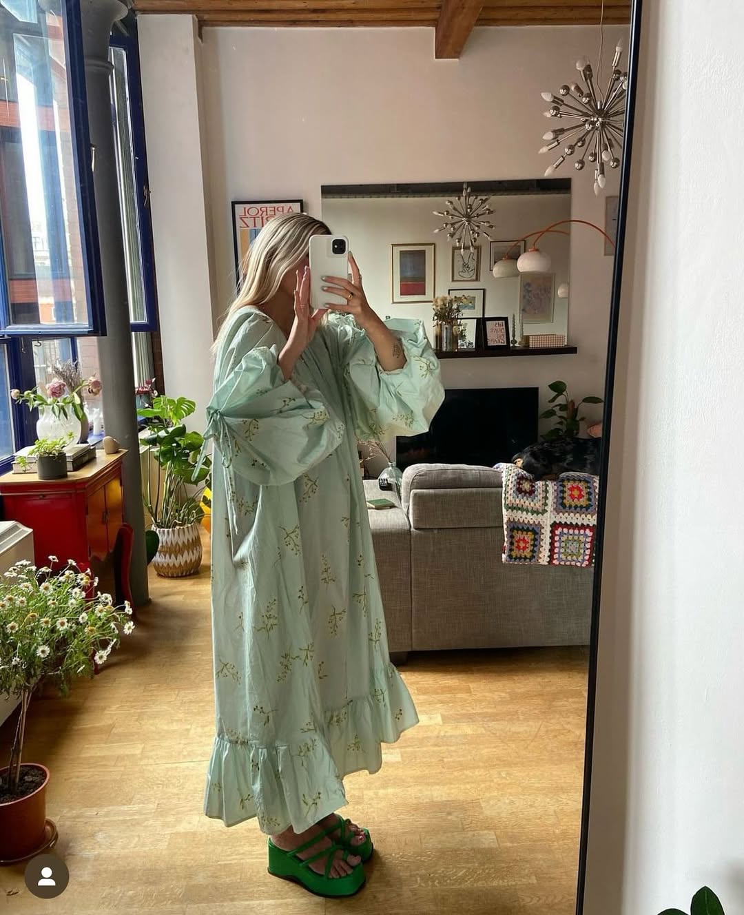 Mulher tirando foto no espelho usando vestido fluido verde menta