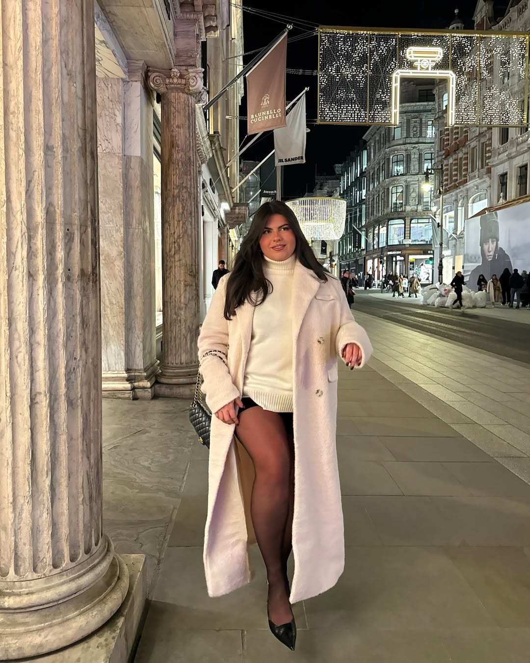 Look com sobretudo rosa, blusa offwhite, shorts e meia cal&ccedil;a preta