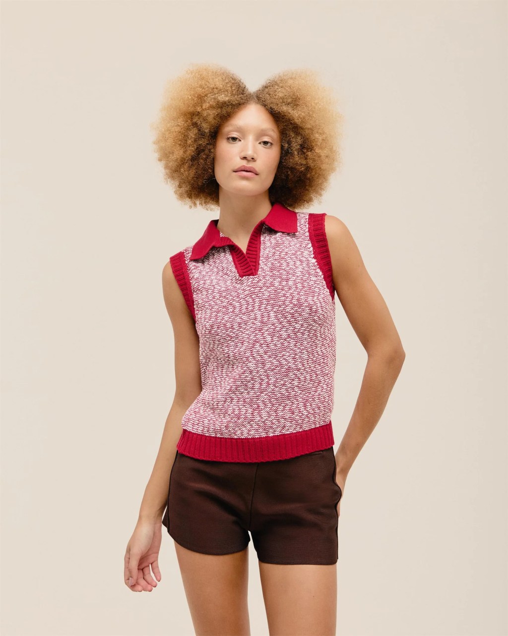 Foto de uma mulher negra usando um colete de tric&ocirc; rosa e vermelho