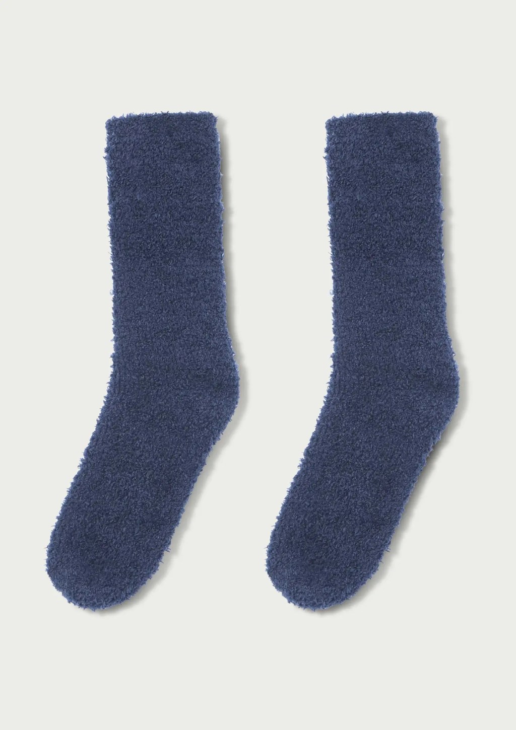 Par de meias felpudas azul-marinho, com textura macia e aconchegante, dispostas lado a lado em fundo branco