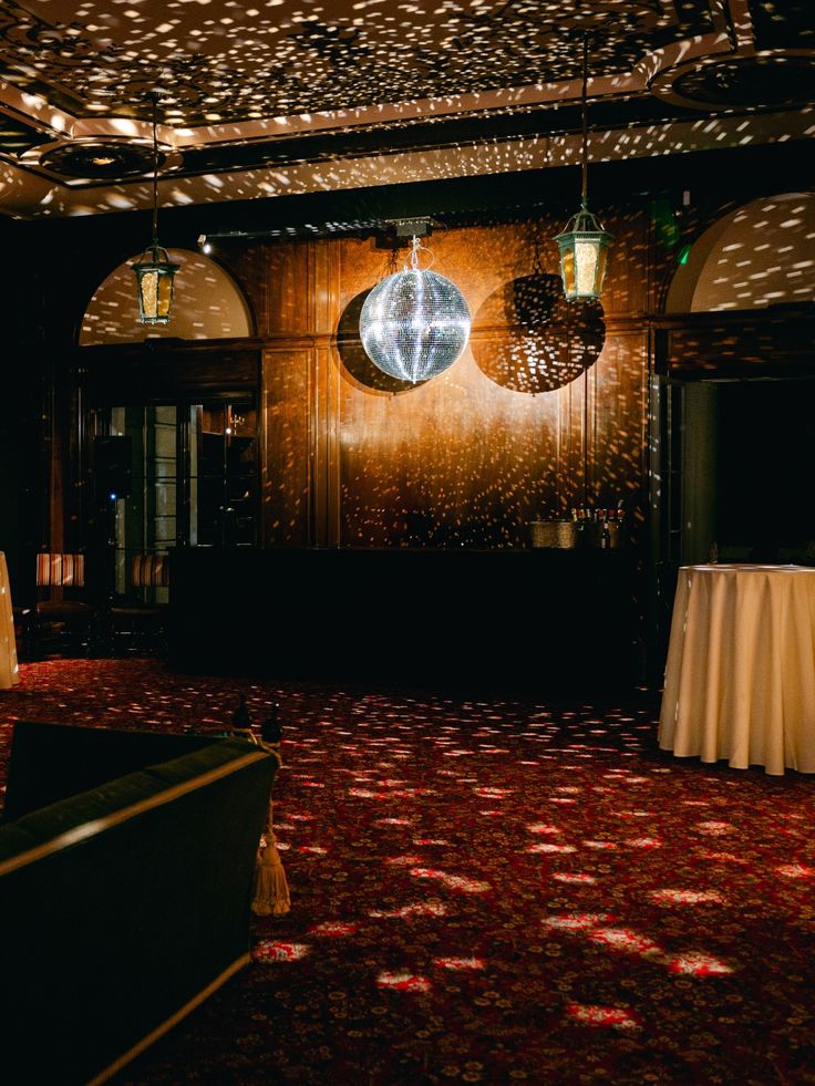 Globo de discoteca espelhado suspenso em sal&atilde;o cl&aacute;ssico com carpete floral