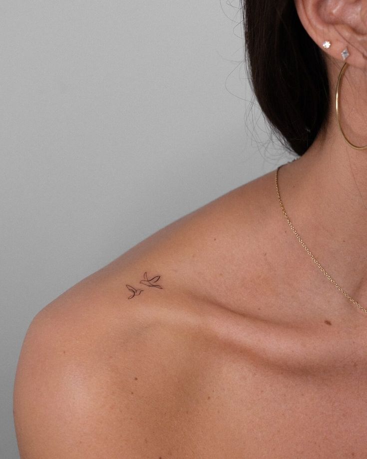 Dois p&aacute;ssaros em fine line no ombro, minimalismo e eleg&acirc;ncia em uma s&oacute; tatuagem