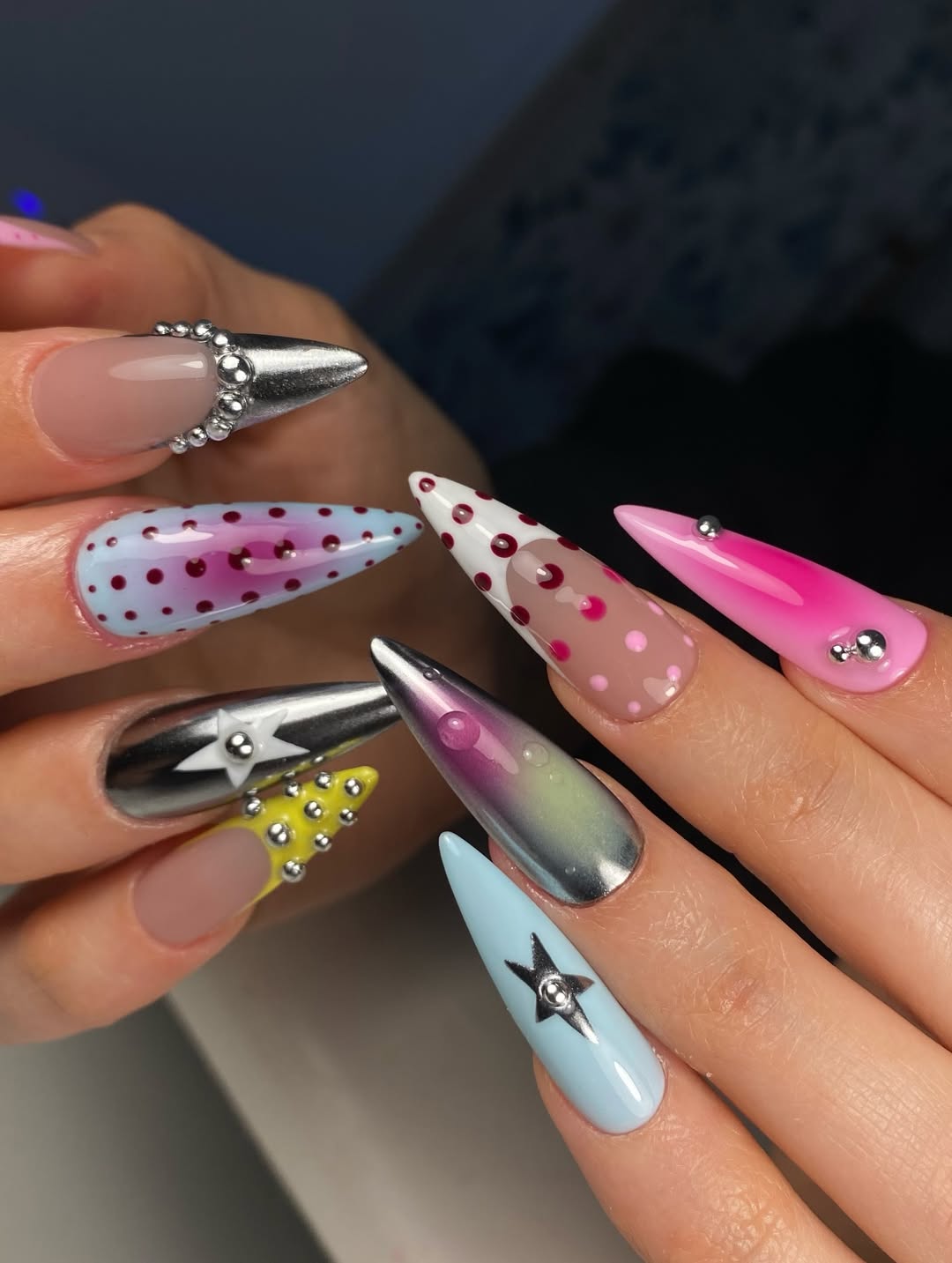 Nail art maximalista stiletto colorida com bolinhas e estrelas 3D