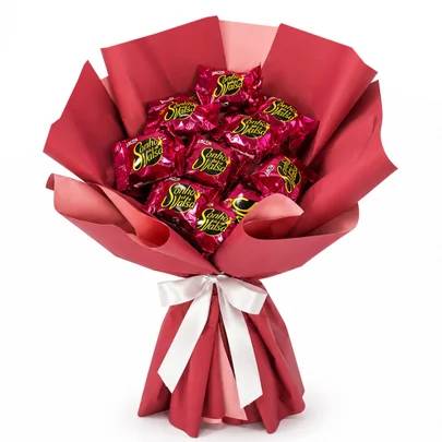 Buqu&ecirc; de bombons Sonho de Valsa, com cerca de dez unidades, envoltos em papel celofane rosa-choque, dispostos em papel de seda vermelho e rosa claro, amarrado com um la&ccedil;o de fita branca