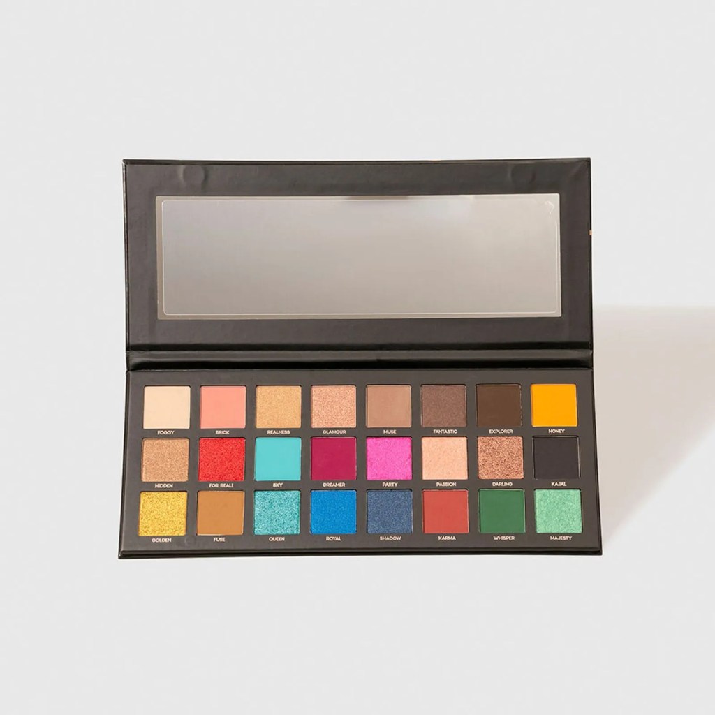 Paleta de maquiagem preta aberta com espelho retangular e 24 sombras coloridas, incluindo tons neutros, vibrantes e cintilantes, cada uma com um nome como Golden, Royal e Majesty