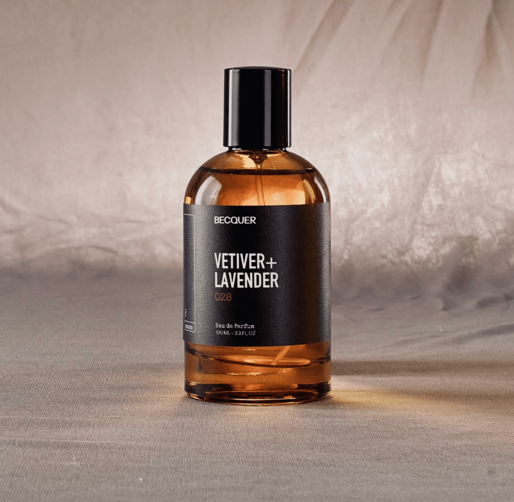 Frasco de perfume Becquer Vetiver + Lavender 028, 100ml, com l&iacute;quido &acirc;mbar, tampa preta e r&oacute;tulo preto com letras brancas, sobre superf&iacute;cie cinza