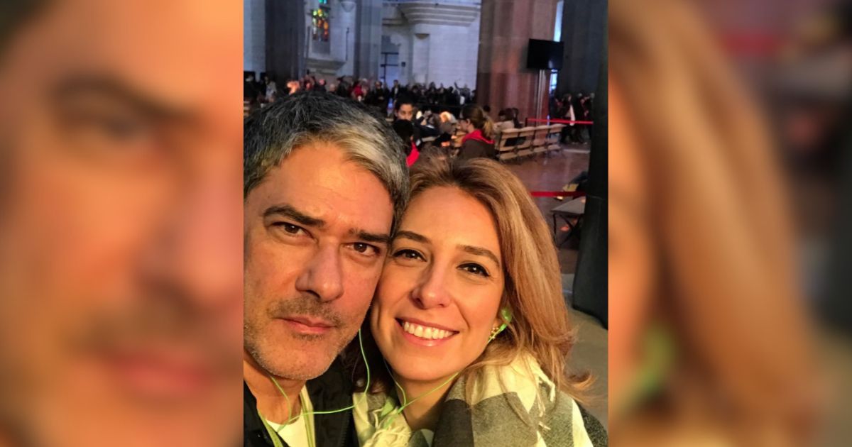 Um homem de cabelos grisalhos e uma mulher de cabelos loiros sorriem para a c&acirc;mera, usando fones de ouvido verdes, em um ambiente interno com muitas pessoas ao fundo