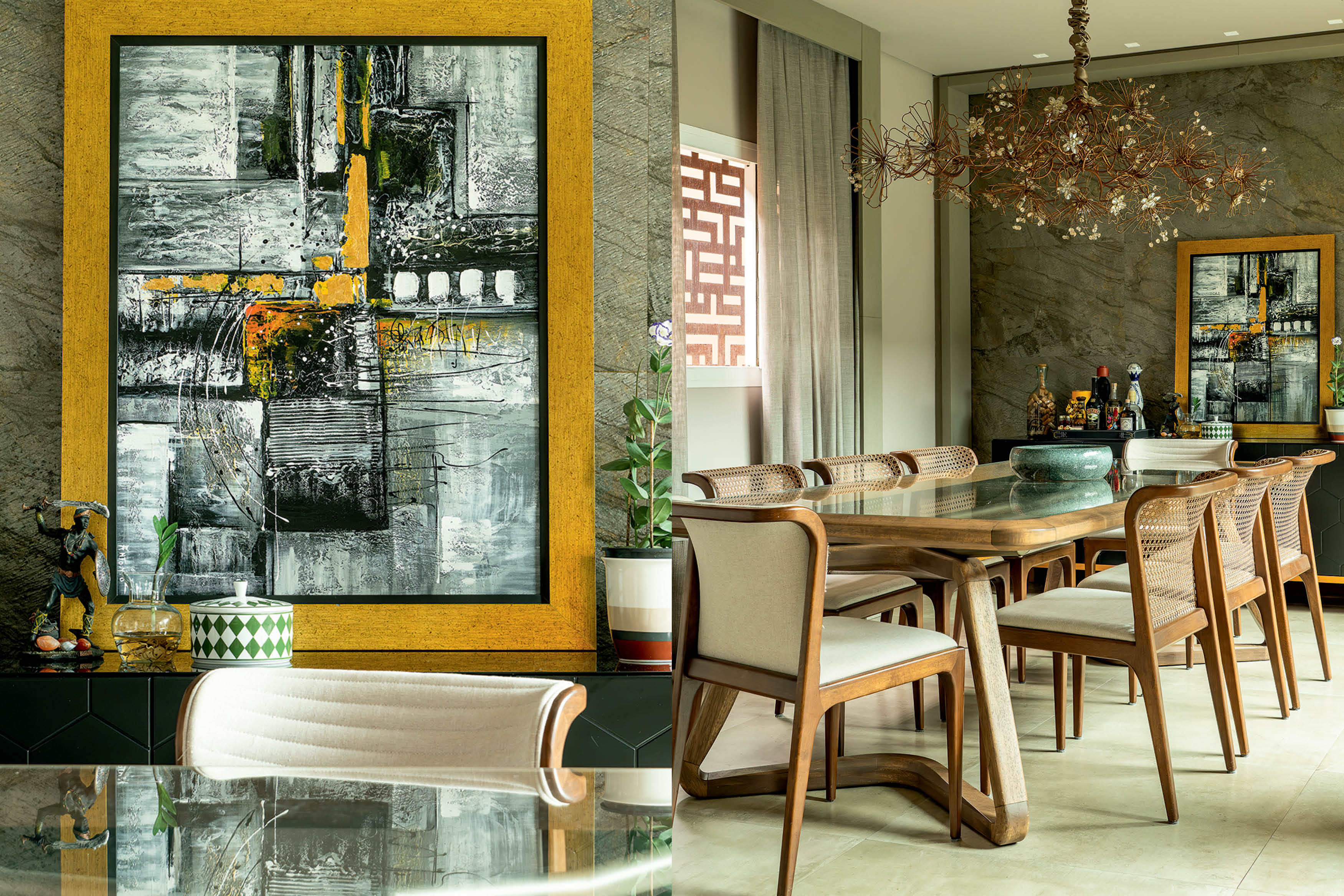 Pintura abstrata em tons de cinza, preto e amarelo vibrante, com moldura dourada, ao lado de uma sala de jantar com mesa de madeira e cadeiras estofadas, sob um lustre floral de metal