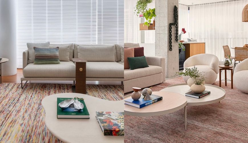 Sala de estar moderna com sof&aacute; bege, almofadas coloridas, mesas de centro com livros e objetos decorativos, poltronas claras e tapetes texturizados em tons terrosos. Cortinas brancas e plantas penduradas complementam o ambiente.