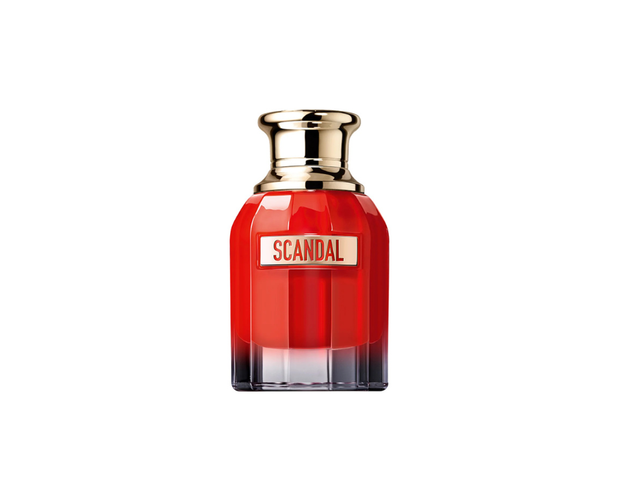 Frasco de perfume Scandal em vidro vermelho transl&uacute;cido, com base preta degrad&ecirc; e tampa dourada. No centro, uma etiqueta dourada com o nome SCANDAL em letras vermelhas
